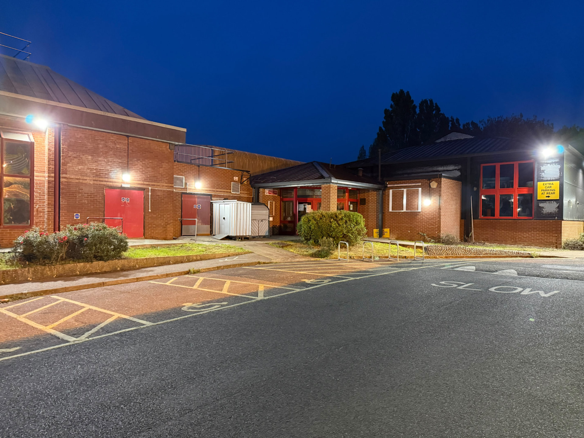 external LED wall lighting on a leisure centre at night, courtyard and car park lighting