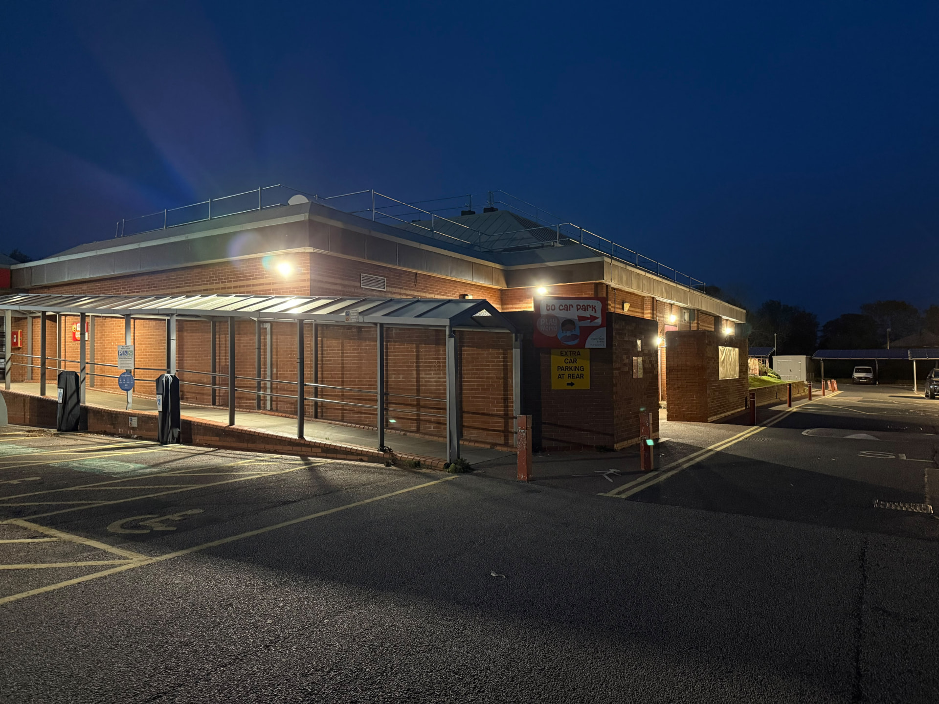 external LED wall lighting on a leisure centre at night, covered entrance lit up